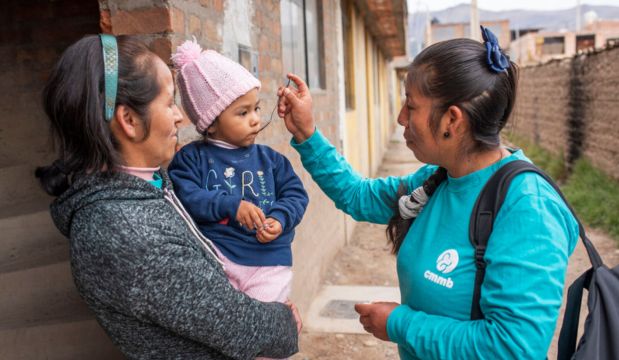 Community Health Agent Rosario Matos Carvajal gives her iron supplement to child member of the CHAMPS Project